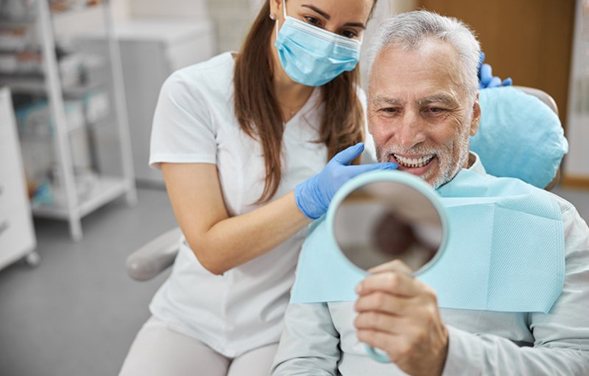 a patient smiling after receiving his dental restorations