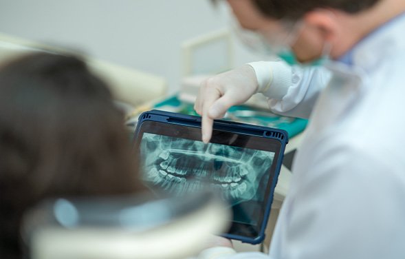 Dentist and patient reviewing X-ray together