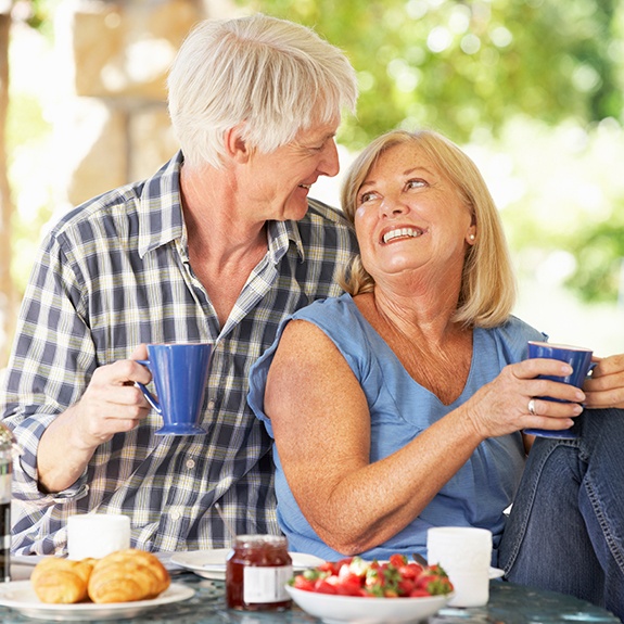 Senior couple eating a romantic breakfast outdoors