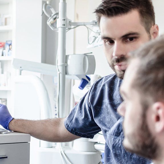 a dentist showing his patient X-rays